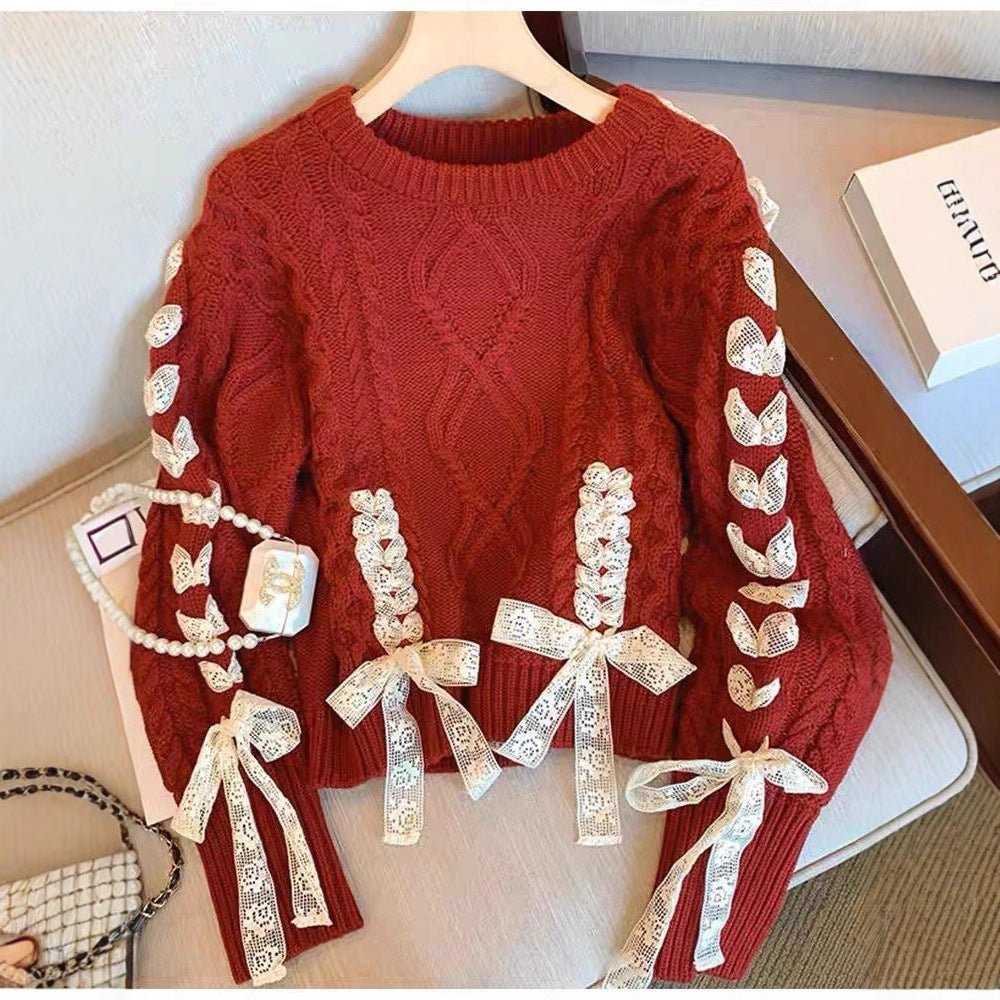 Red sweater with lace details on a hanger against a neutral background