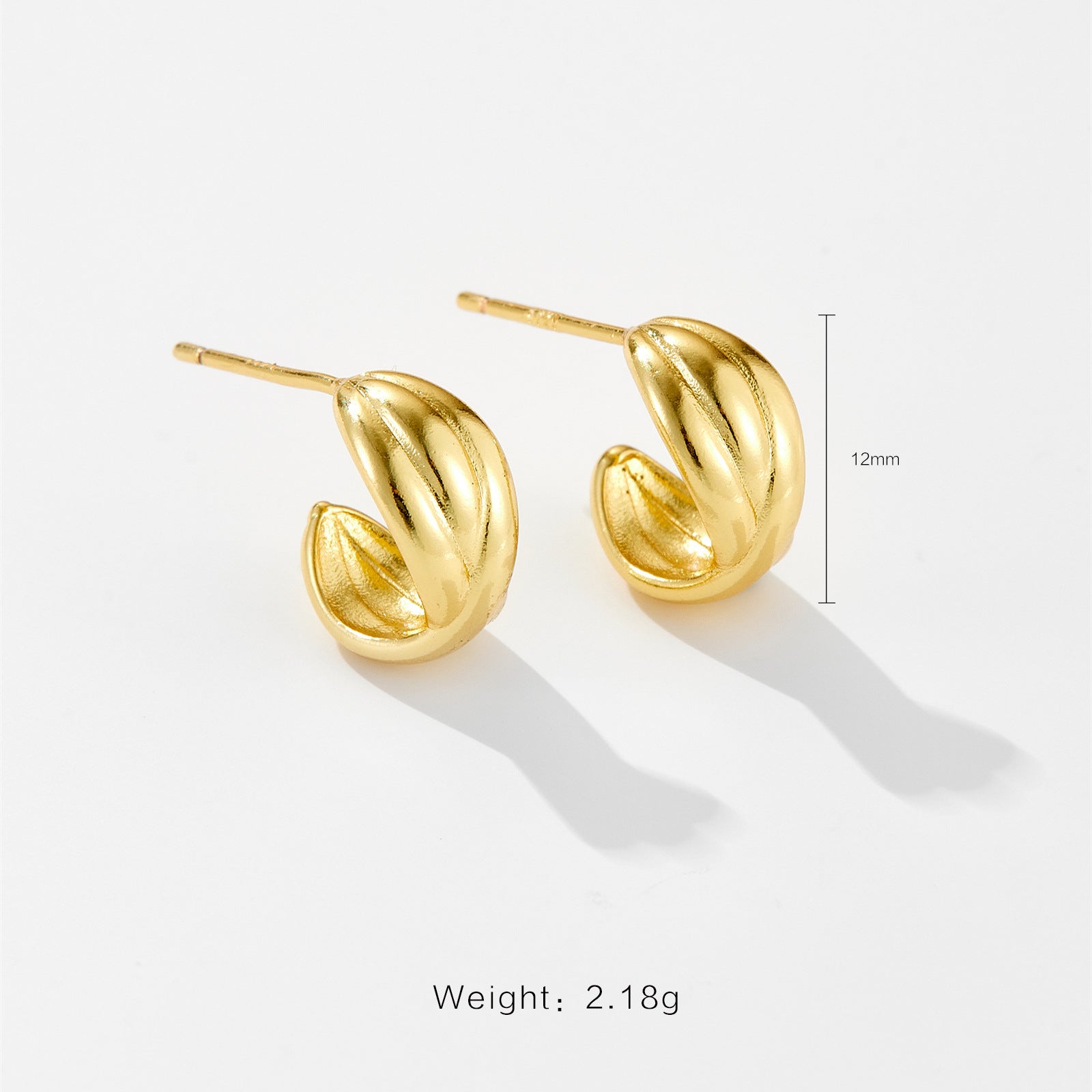 Pair of small gold-toned textured half-hoop stud earrings on white background