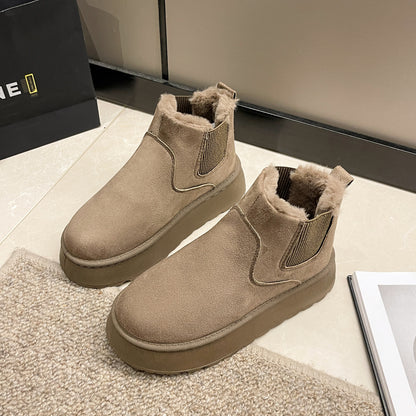 Beige suede winter boots with plush fur lining on tiled floor next to carpet and magazine