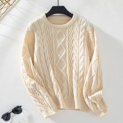 Cream cable knit sweater on black hanger with black sunglasses on white background