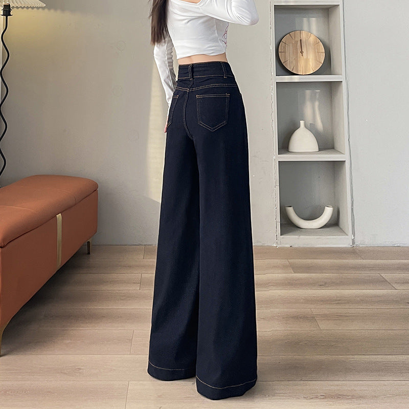 Woman wearing high-waisted wide-leg black denim jeans and white long-sleeve crop top indoors