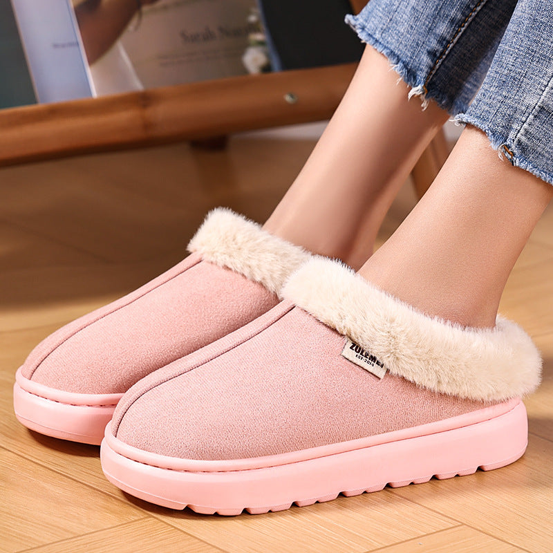 Pink slippers with fluffy trim worn indoors on a wooden floor.