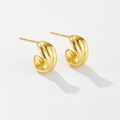 Pair of small shiny gold hoop earrings with ridged design on white background