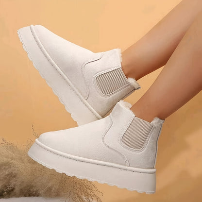 White suede platform ankle boots with elastic side panels and fur lining on model legs