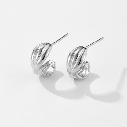 Pair of shiny silver twisted hoop stud earrings on white background