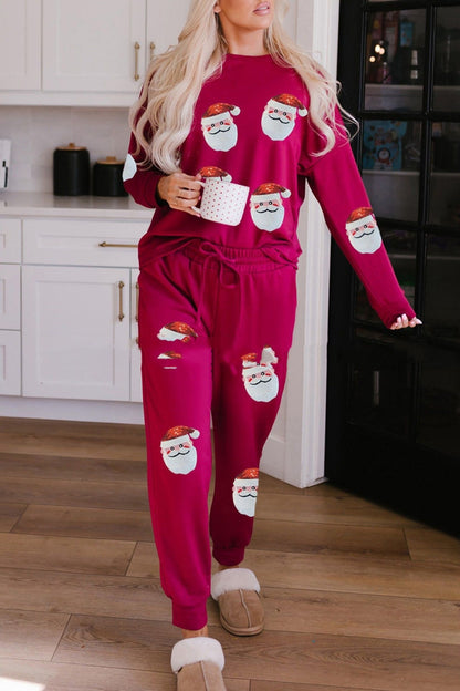 Woman wearing a matching red Christmas-themed sweater and pants set in a kitchen.