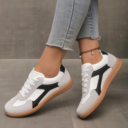 White and black casual sneakers with gum soles worn with cropped frayed jeans and pearl anklet