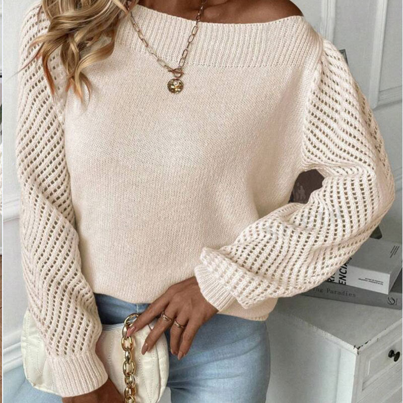 Woman wearing beige knit sweater with openwork sleeves and holding white quilted handbag with gold chain