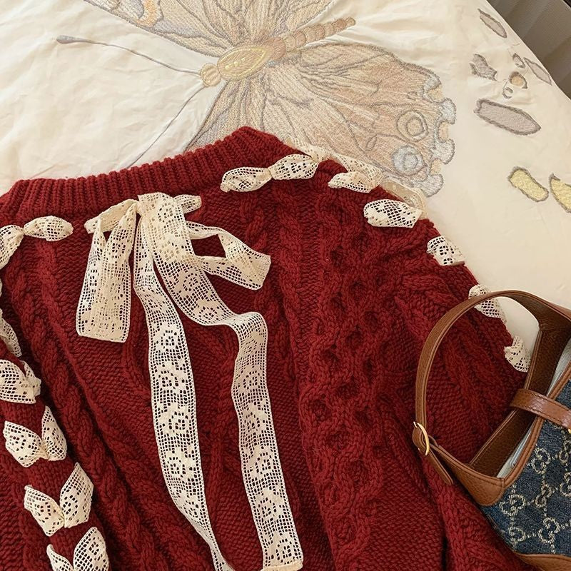 Red sweater with lace details on a white surface