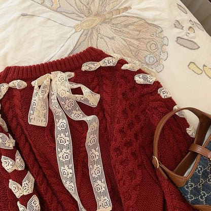 Red sweater with lace details on a white surface