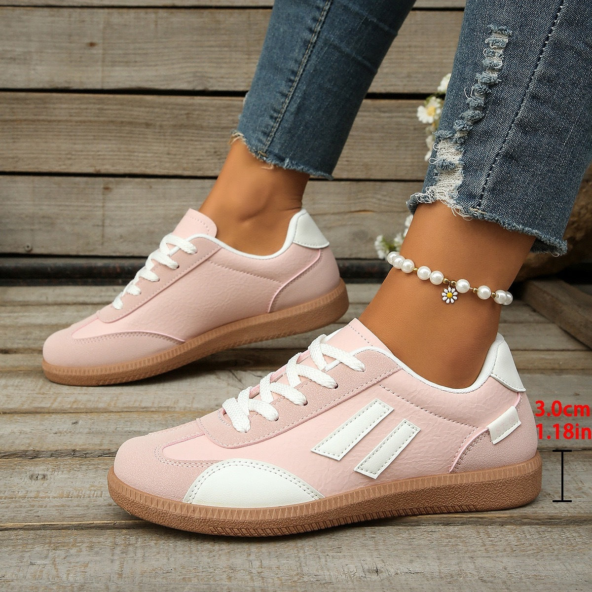 Pink and white casual sneakers with white laces worn with distressed blue jeans and a pearl anklet